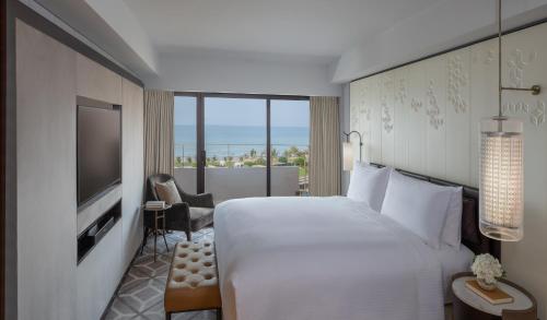 a hotel room with a large bed and a television at InterContinental Muscat by IHG in Muscat