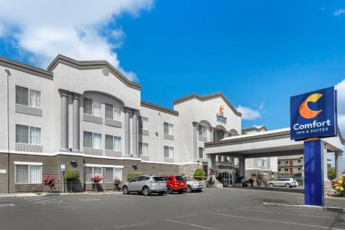 a hotel with cars parked in front of a building at Comfort Inn & Suites Sacramento - University Area in Sacramento