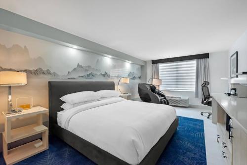 a bedroom with a bed and a desk and a chair at Blue A Modern Hotel, an Ascend Collection Hotel in West Springfield