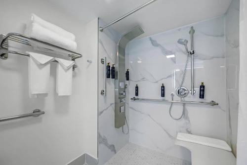 a white bathroom with a shower and a toilet at Blue A Modern Hotel, an Ascend Collection Hotel in West Springfield