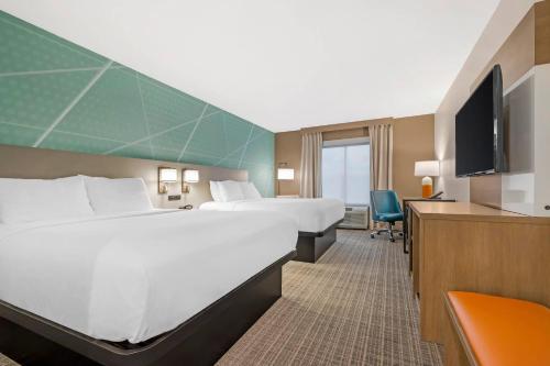 a hotel room with two beds and a flat screen tv at Comfort Inn Sullivan in Sullivan