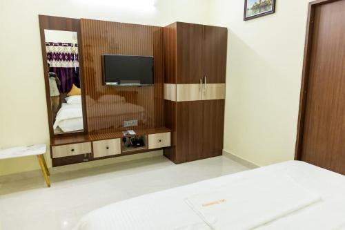 a bedroom with a mirror and a bed and a tv at SKS Residensy in Kāraikkudi