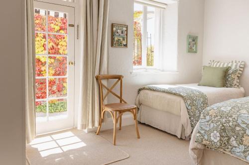 a bedroom with a bed and a chair and a window at Maison del Mar in Hobart