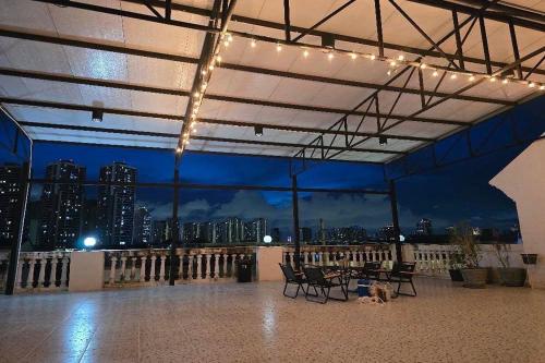 a patio with chairs and a table with a view of a city at Sukhum Huai Khwang Guest House in Bangkok