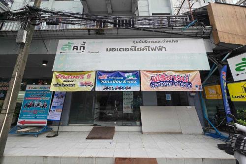 a store with signs on the front of a building at Sukhum Huai Khwang Guest House in Bangkok