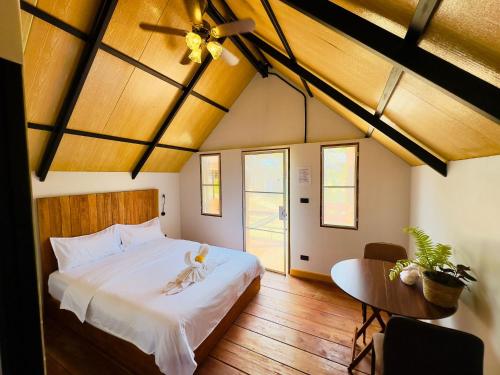 a bedroom with a large white bed and a table at Phayam Paradise Resort in Ko Phayam