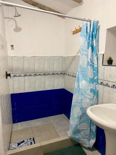a bathroom with a blue shower curtain and a sink at Authentic Peruvian home with gorgeous patio in Pisac