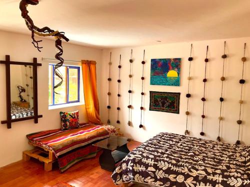 a bedroom with a bed and a bench in it at Authentic Peruvian home with gorgeous patio in Pisac