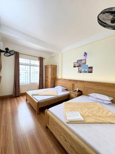a bedroom with two beds and a window at Hương Dịu Hotel đảo Quan Lạn in Quan Lạn