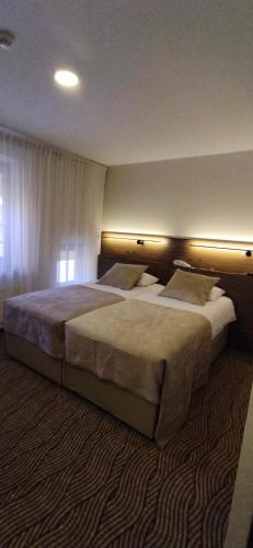 ein Hotelzimmer mit zwei großen Betten in der Unterkunft Gilija in Šilutė