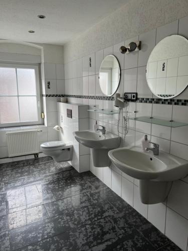 a bathroom with two sinks and two mirrors at Tilla's Hof in Hamm