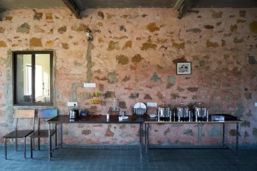 a room with a table and chairs and a wall at Bagh Ajabgarh in Ajabgarh