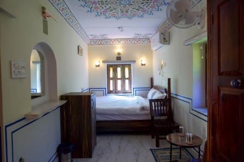 a bedroom with a bed and a window and a table at Bagh Ajabgarh in Ajabgarh