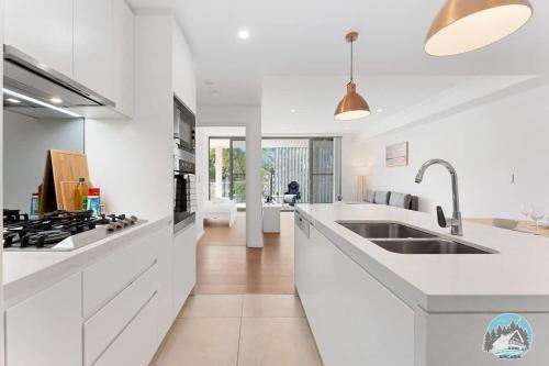 a white kitchen with a sink and a stove at Epping 2BR House with Parking in Epping
