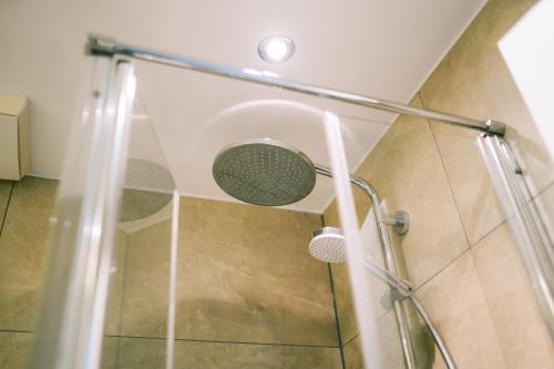 a shower with a glass door in a bathroom at DämeritzSeehotel in Berlin
