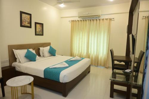 a bedroom with a bed and a desk and a television at Hotel Casa Lorven Near Golf Course in Visakhapatnam