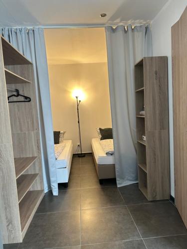 a room with a bed and a couch and shelves at Pension Boardinghaus Dingolfing in Dingolfing
