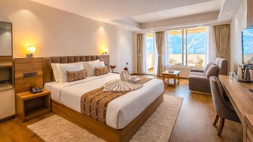 a bedroom with a large bed and a living room at Yashshree Dewathang Resort in Lachung