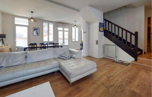 a living room with a white couch and a staircase at Charmante Maison Proche Mer in Royan