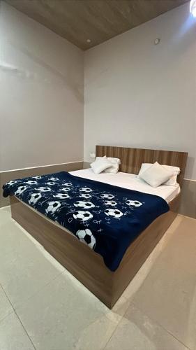 a bedroom with a bed with a blue and white blanket at Hotel Moonlight in Chhatikara