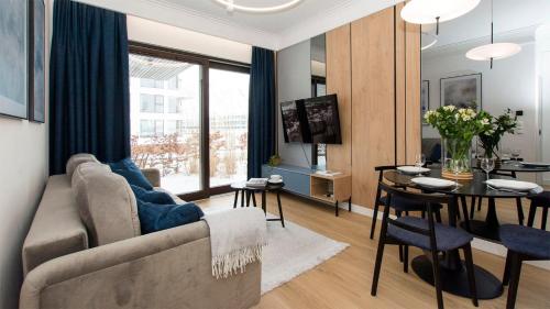 a living room with a couch and a table at Sol Marina - Lazur in Wiślinka