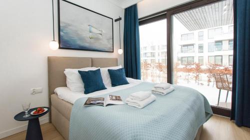 a bedroom with a large bed with towels and a window at Sol Marina - Lazur in Wiślinka