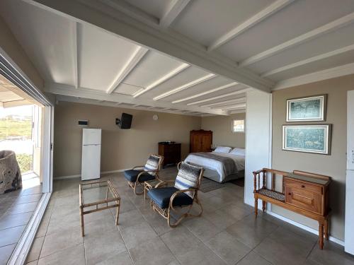 a bedroom with a bed and a table and chairs at Ganstever Suiderstrand Western Cape in Suiderstrand