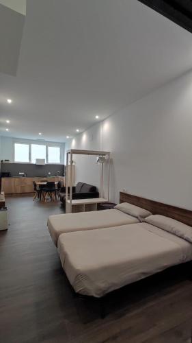 a large bedroom with two beds and a table at Apartamentos Turísticos Betanzos in Betanzos