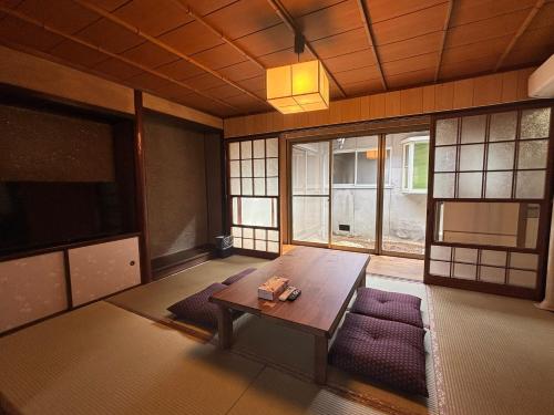 a room with a table and chairs and windows at P-Stay宮島西連町 in Hatsukaichi