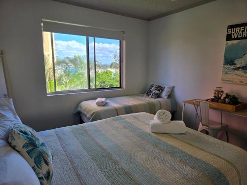 a small room with two beds and a window at CHILL-OUT BEACHSIDE - Main Beach Forster in Forster