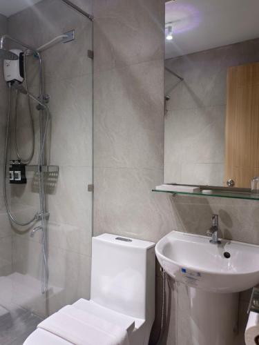 a bathroom with a shower and a toilet and a sink at Verdant Villas in Kaybagal