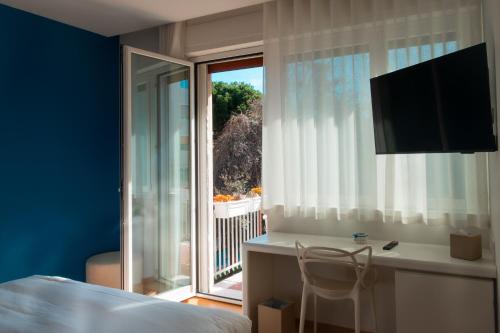 a bedroom with a bed and a desk and a window at Le Ciulla Luxury B&B in Pescara
