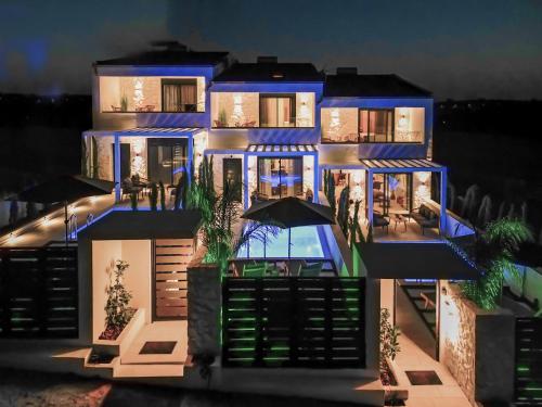 a large house with blue lighting in front of it at Kara Villas in Kallithea Halkidikis