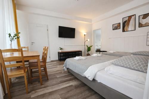 a bedroom with a bed and a table and a desk at Spacious House in Düsseldorf