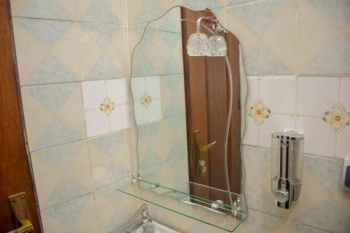 a shower in a bathroom with a tile wall at Appart Naxel in Kinshasa