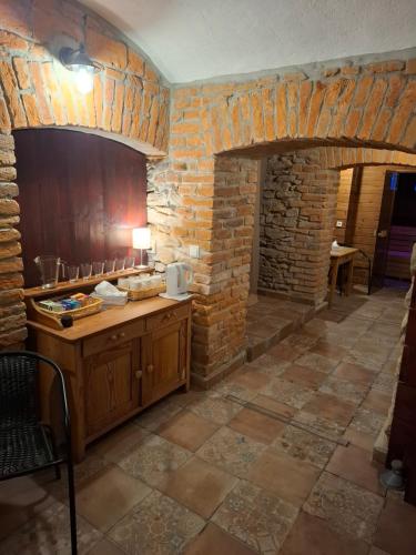 a kitchen with a brick wall and a table with a microwave at Wellness Apartmány Vízmberk in Velké Losiny