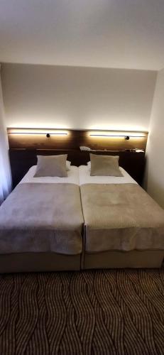 ein Schlafzimmer mit zwei Betten und Lampen in der Unterkunft Gilija in Šilutė