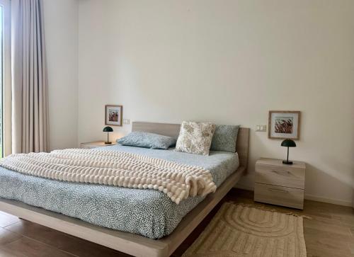 a bedroom with a bed and two night stands and a window at Respiro di Tramonto in Montegranaro