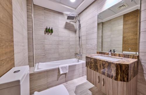 a bathroom with a tub and a sink at Grand Stay Holiday Homes Al Jaddaf in Dubai