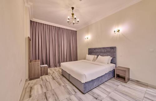 a bedroom with a white bed and a chandelier at Grand Stay Holiday Homes Al Jaddaf in Dubai