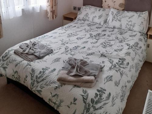 a bed with a blanket and towels on it at Oak in Denny