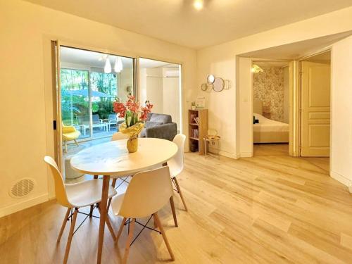 a dining room with a table and chairs and a bedroom at Dou Cocon, Calme et Confort Moderne in Sainte-Clotilde