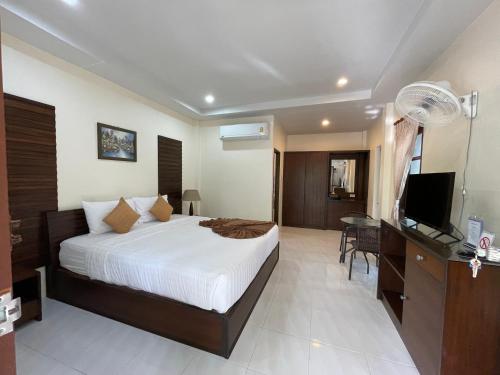 a bedroom with a bed and a desk and a television at Ron Bungalow in Bang Tao Beach
