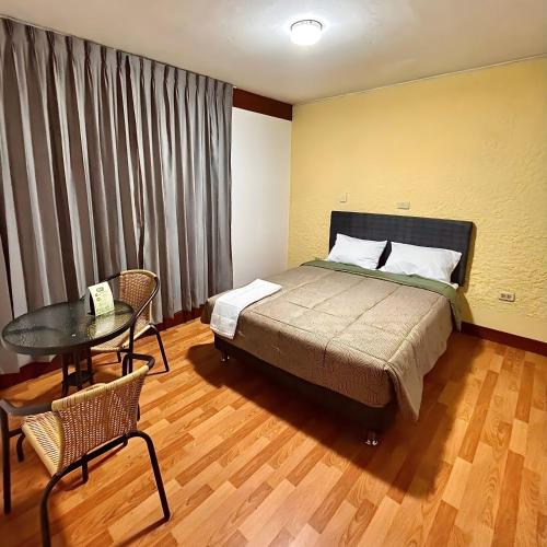 a bedroom with a bed and a table in a room at Lua Hostal - Arequipa in Arequipa