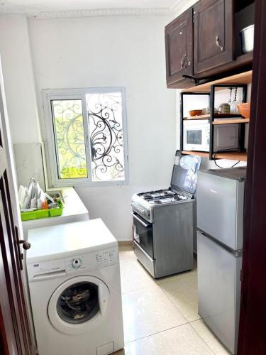 a kitchen with a washing machine and a stove at sidof Redence L&A in Yaoundé