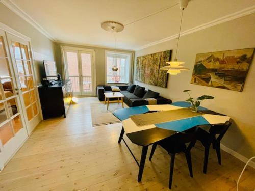 a living room with a table and a couch at Deluxe Hotel Apartment in Charlottenlund