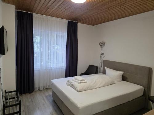 a bedroom with a white bed with a window at Niederdreisbacher Hof in Niederdreisbach