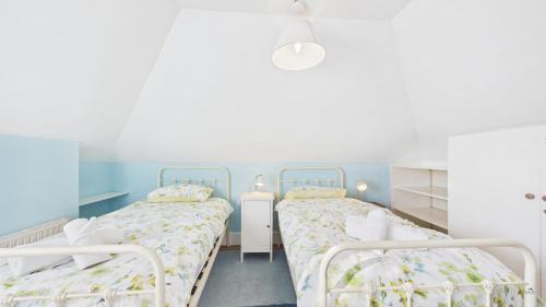 two beds in a room with blue and white at Arden Villa, sleeps 8, moments from the golden sandy beach of Ryde in Ryde