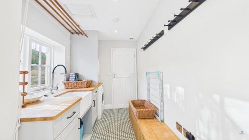 a kitchen with white counters and a sink at Arden Villa, sleeps 8, moments from the golden sandy beach of Ryde in Ryde