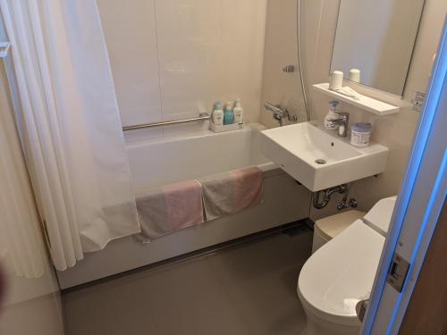 a bathroom with a sink and a shower and a toilet at ル カフェ プランタニエ in Yokote